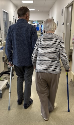 Rear view of parents walking along a hospital corridor of Monash Medical Centre