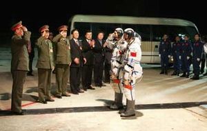 Two taikonauts report to the State Commission Chairman before launch.